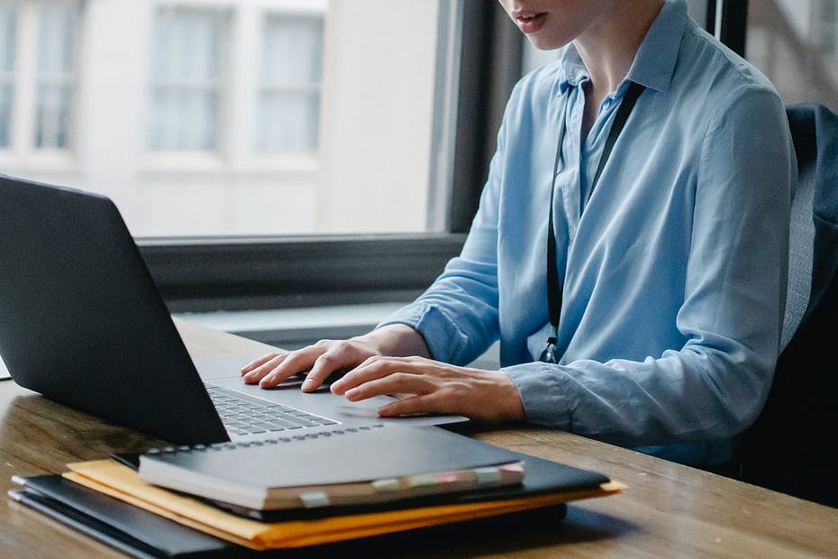 crop female employee working on laptop in office