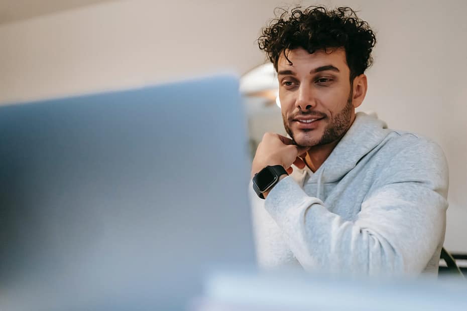 smiling distance employee in smart watch against laptop at home